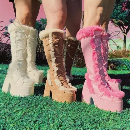 Three women wearing mid-calf platform wedge boots with faux fur trim, lace-up fronts, in white, tan, and pink.