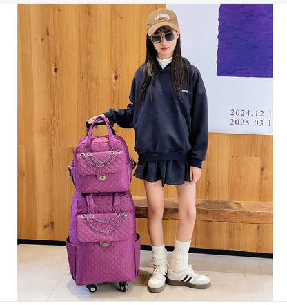 Purple quilted rolling travel luggage and matching backpack with chain detail.