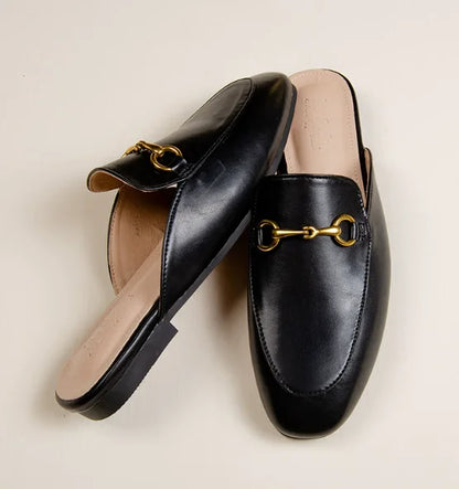 Black slip-on mules with a gold metal chain detail for comfortable outdoor wear.