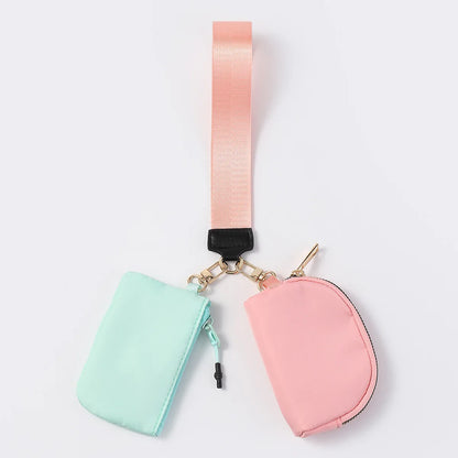 Mint and pink nylon dual pouch wristlet with zip closure for holding cards and coins while on the go.