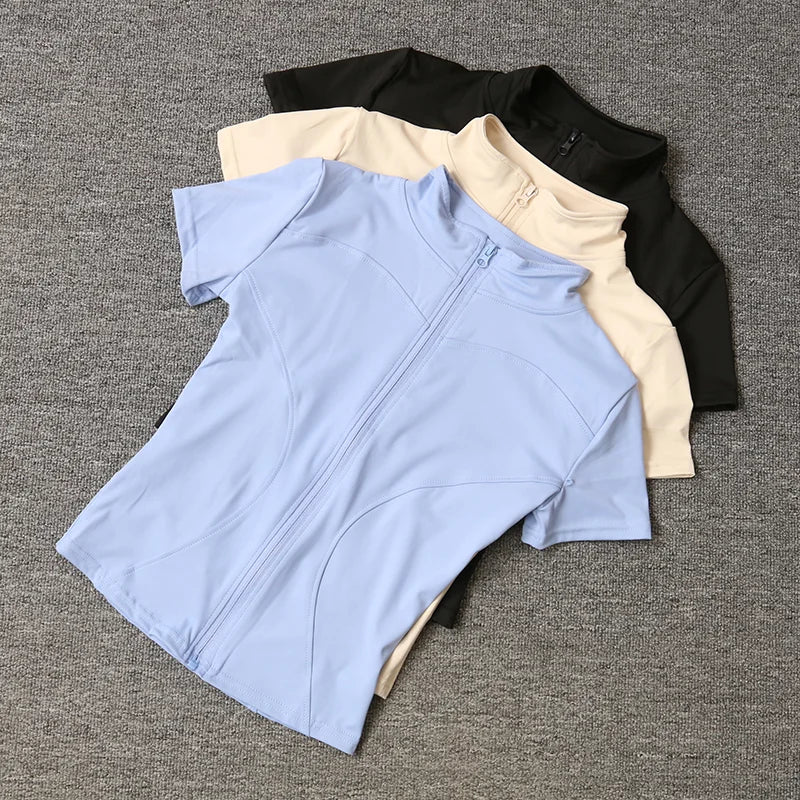 Black, beige, and blue short-sleeve fitted sculpting training tops with a full zip stand collar for yoga workouts.