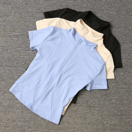 Black, beige, and blue short-sleeve fitted sculpting training tops with a full zip stand collar for yoga workouts.