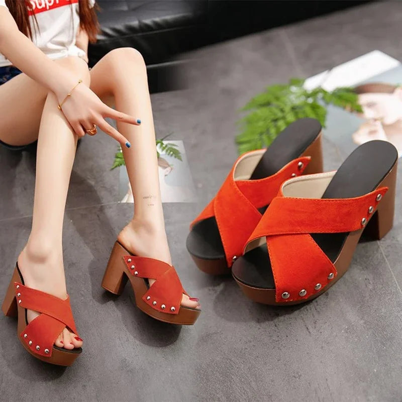 Orange suede platform sandals with rivet details and peep toes as comfortable slip-on footwear for summer outings.