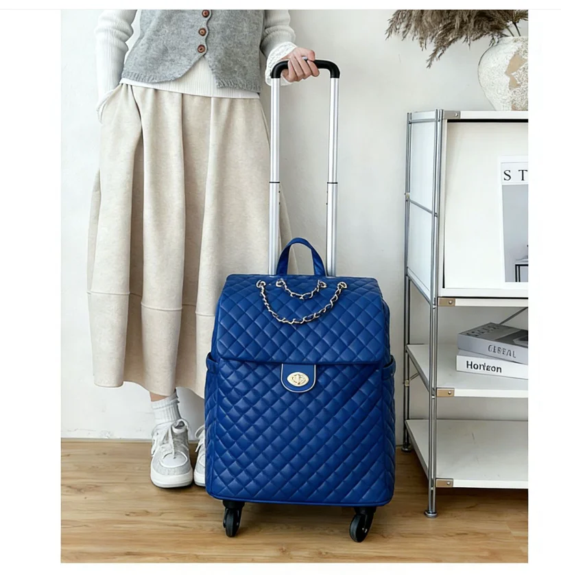 Blue quilted faux leather rolling luggage bag with a chain accent, gold-tone clasp, and a retractable handle.