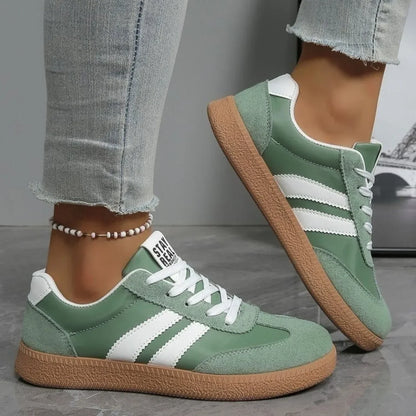 Sage green leather and suede slip-on sneakers with white stripes and gum soles for casual daily wear.