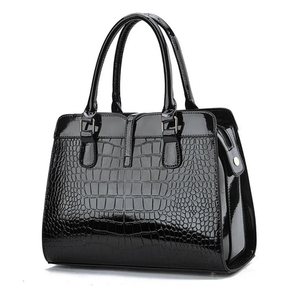 Black glossy crocodile-pattern leather handbag with dual top handles and structured tote design.