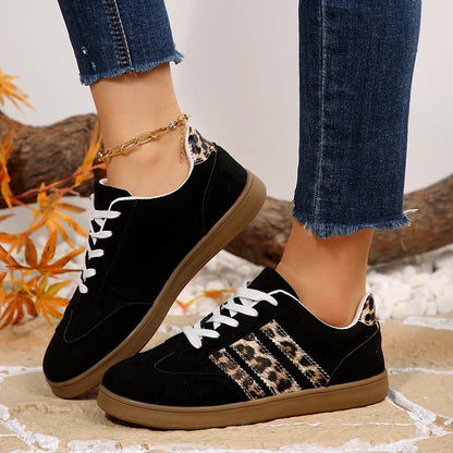 Black suede slip-on sneakers with leopard print side stripes and white laces for comfortable everyday wear.