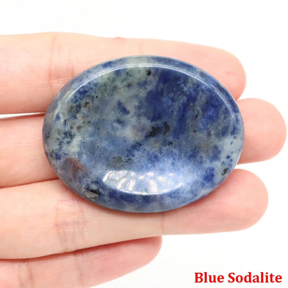 Smooth, blue and white oval-shaped sodalite home decor stone, held in a palm for mindfulness and meditation.