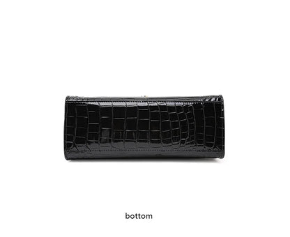Black glossy cowhide handbag with a crocodile pattern, showing the flat bottom view.