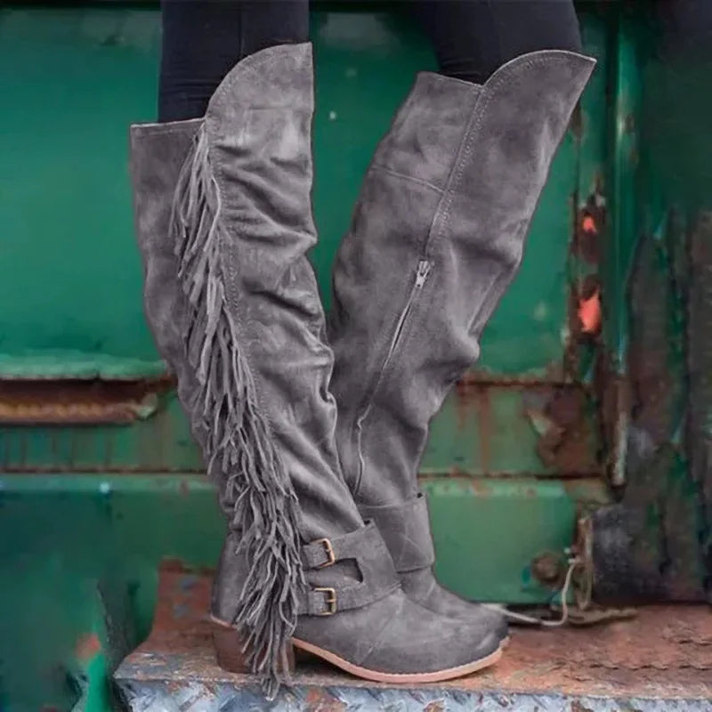 Gray suede over-the-knee boots with long fringe, dual ankle straps, buckles, side zippers, and thick heels.