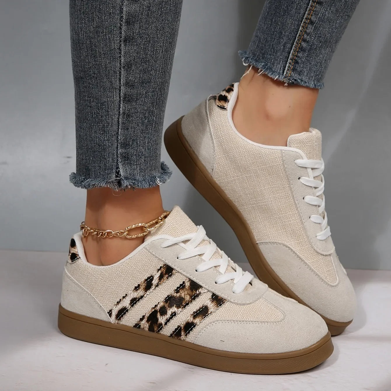 Beige and leopard print canvas slip-on sneakers with a flat brown sole for casual walking.