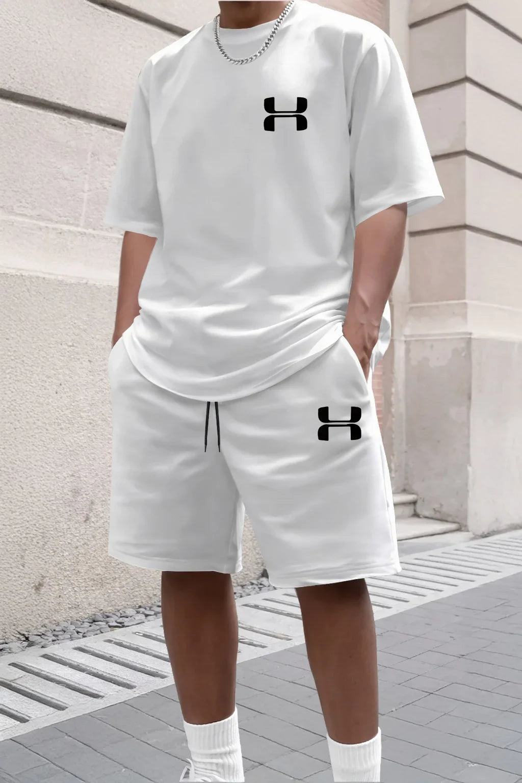 White relaxed knit set with short sleeve tee and shorts, featuring black logo accents for casual athletic wear.
