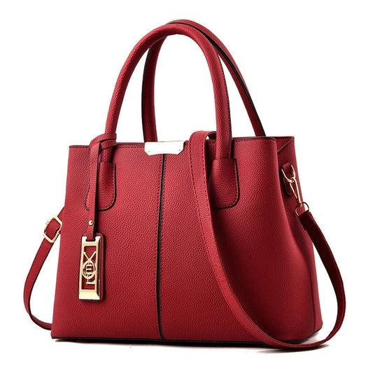 Red structured tote handbag with rolled top handles, a detachable shoulder strap, and gold-tone hardware accent.