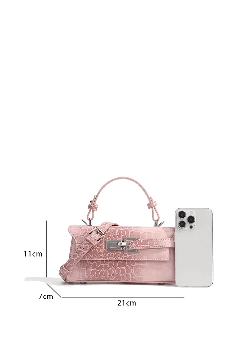 Light pink faux leather crossbody bag with crocodile texture, metal latch, and adjustable strap for everyday carry.