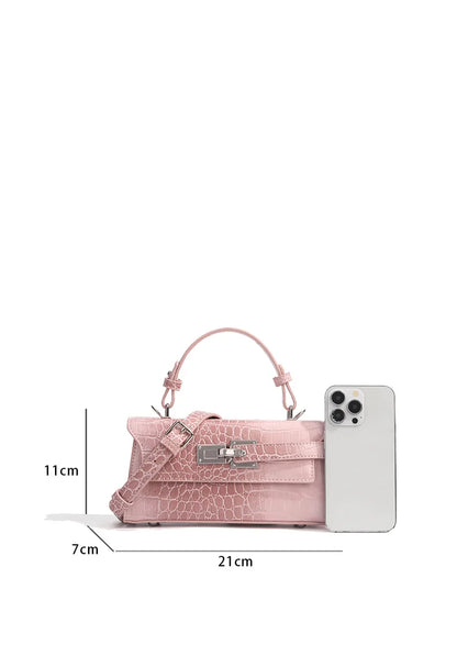 Light pink faux leather crossbody bag with crocodile texture, metal latch, and adjustable strap for everyday carry.