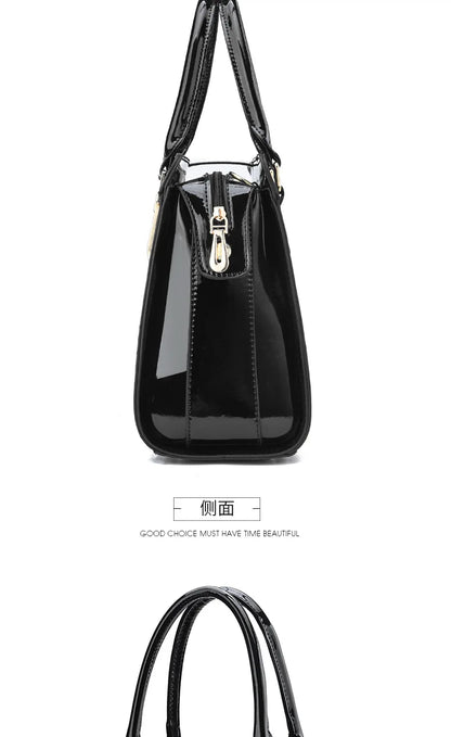 Black patent leather handbag with dual top handles, side zipper, and gold hardware.