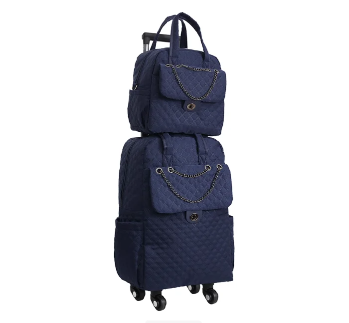 Navy blue quilted rolling luggage set with a matching smaller backpack, chain flap accents, and trolley wheels.