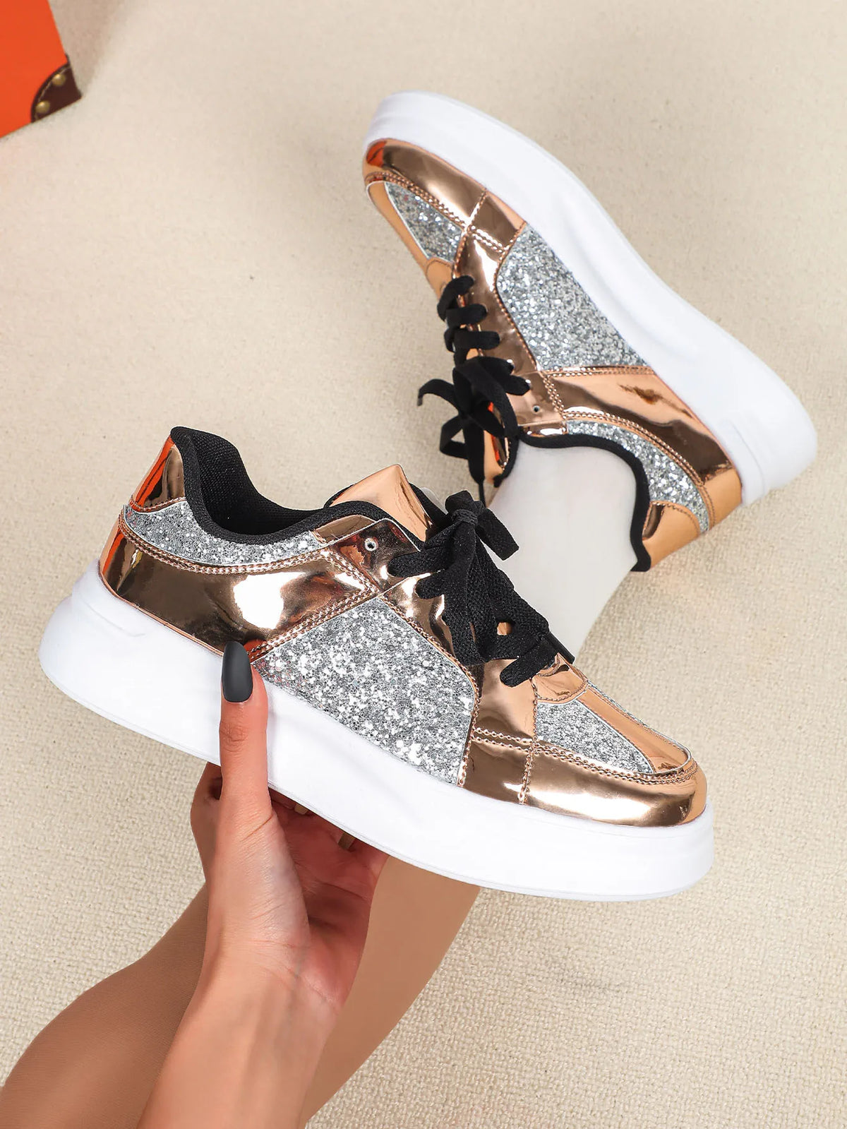 Rose gold metallic and silver glitter sneakers with thick white soles and black laces.