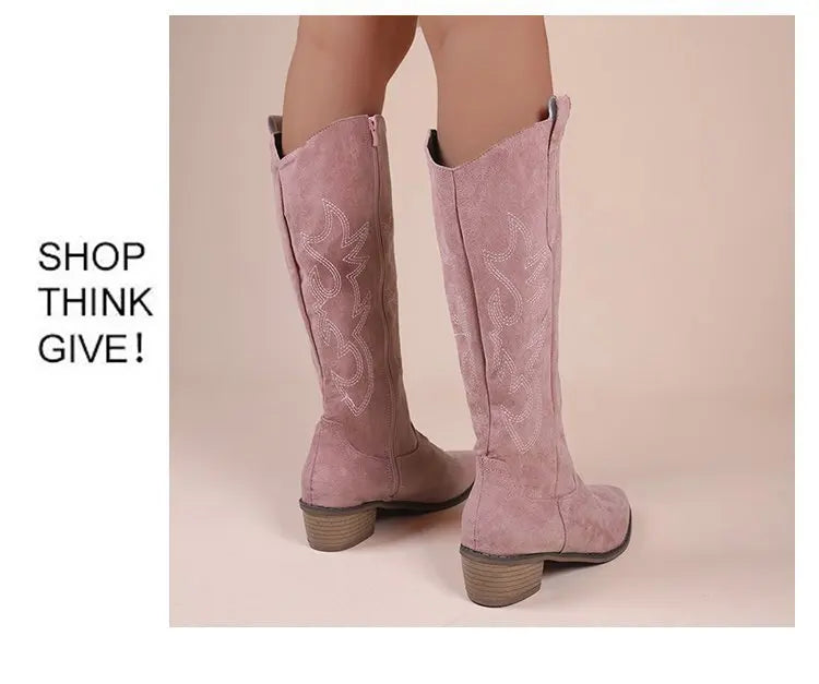 Pink suede western cowboy boots with white embroidery, block heels, and tall shafts.