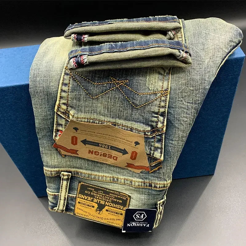 Faded blue, stretchy denim tapered jeans with contrast stitching and branded leather patches for daily comfort.