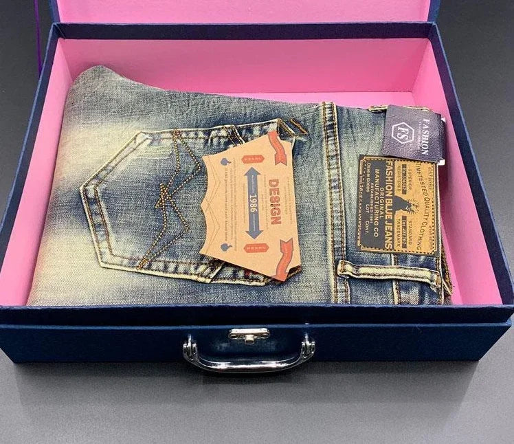 Faded blue, stretchy tapered jeans with gold stitching in a gift box for daily comfort.