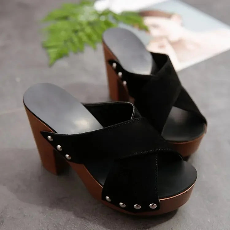Black flock platform sandals with rivet details and wood-tone heels, these slip-on shoes are ready for casual wear.