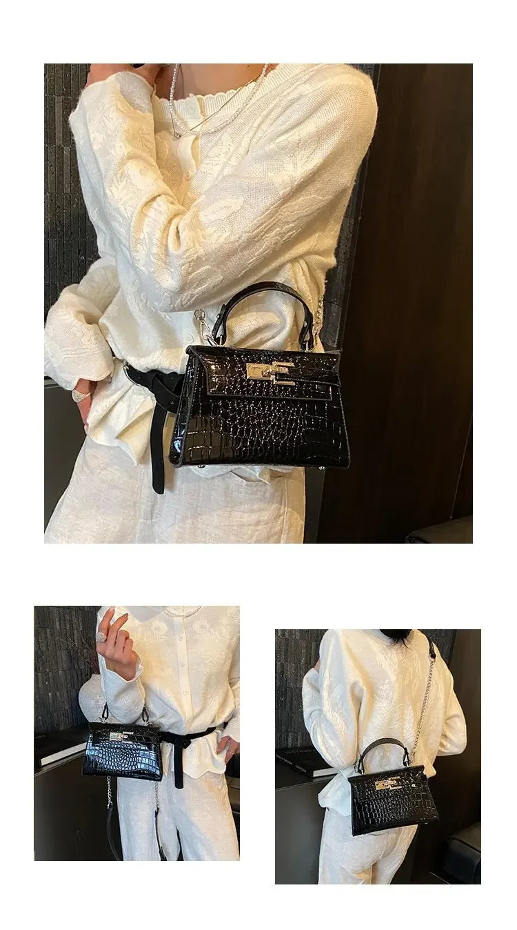 Black croc-embossed structured crossbody bag with gold hardware for carrying baby essentials.