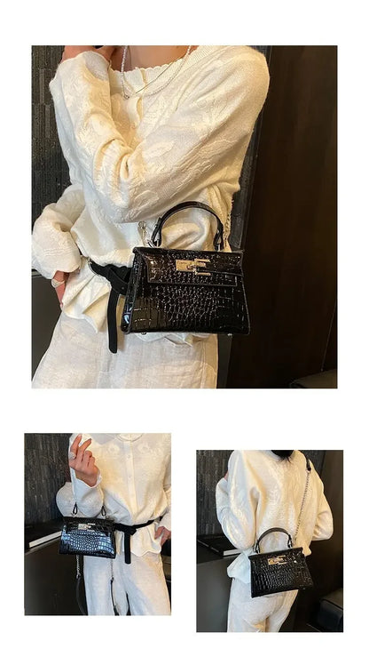 Black croc-embossed structured crossbody bag with gold hardware for carrying baby essentials.