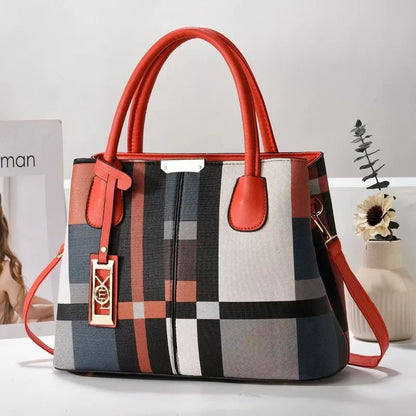 Multi-colored plaid structured tote bag with orange trim, zip closure, and crossbody strap for everyday use.