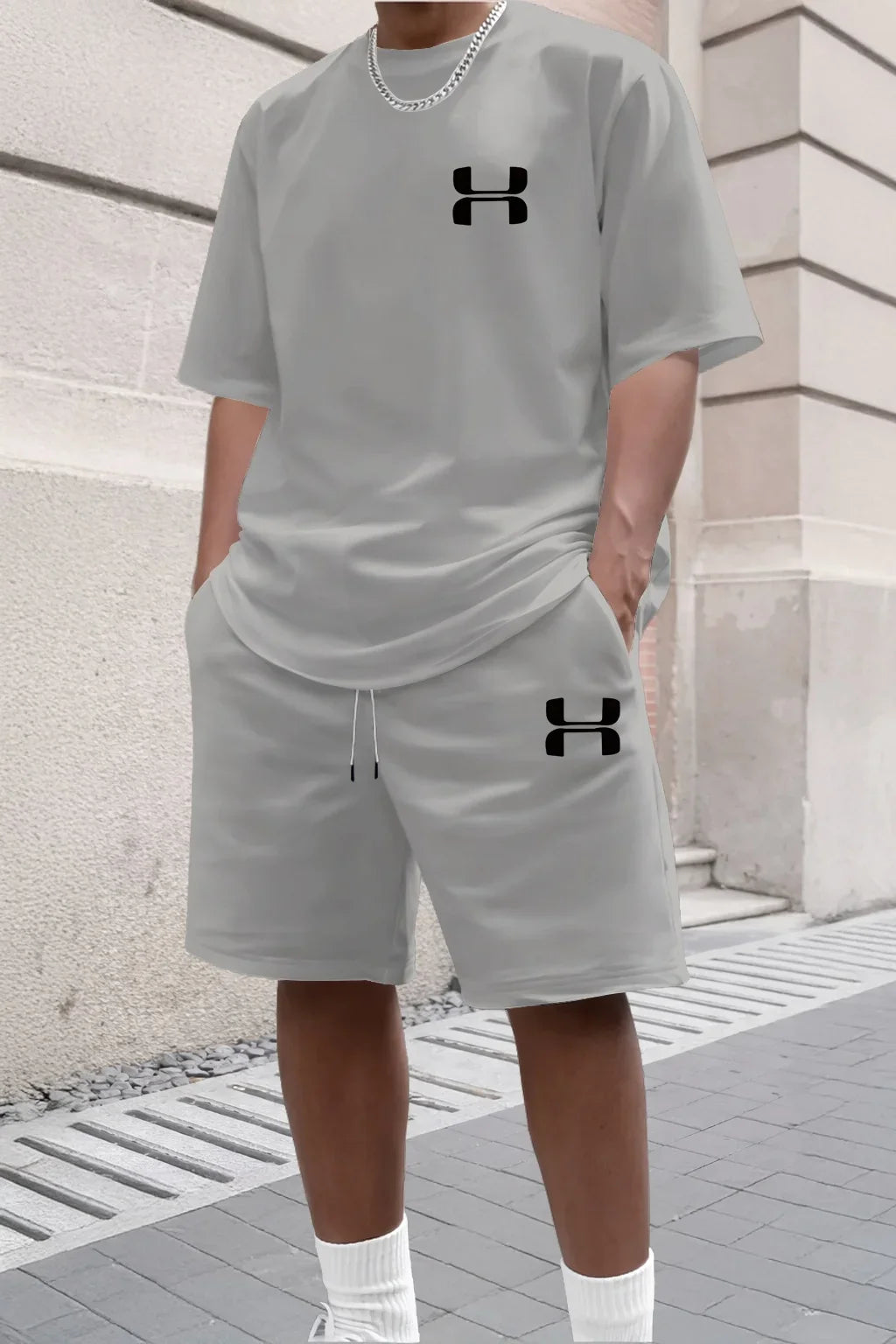 Light gray knit shorts and tee set with black logos for a relaxed fit during workouts or casual wear.