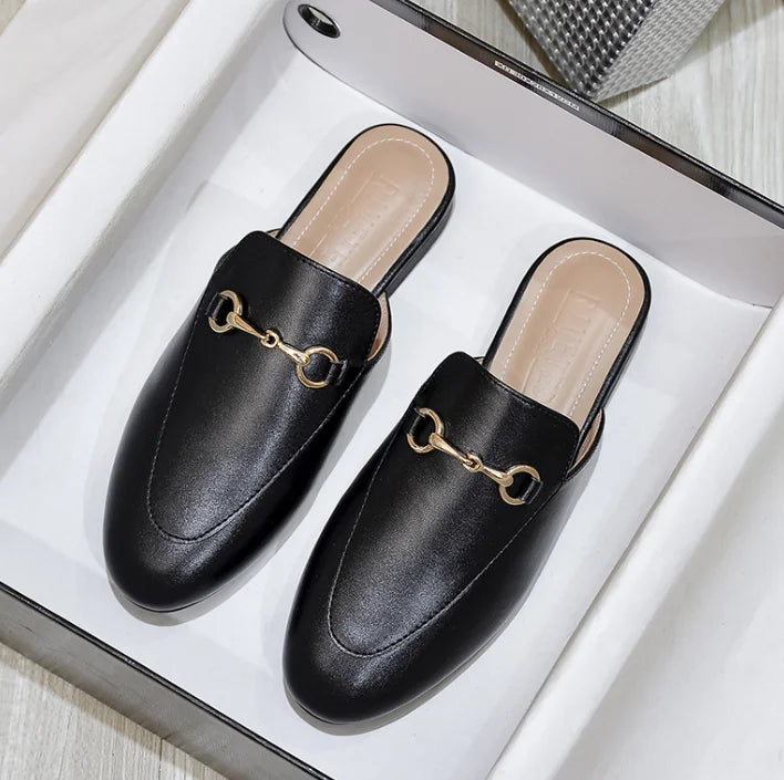 Black leather slip-on mules with a gold metal chain detail for outdoor wear.