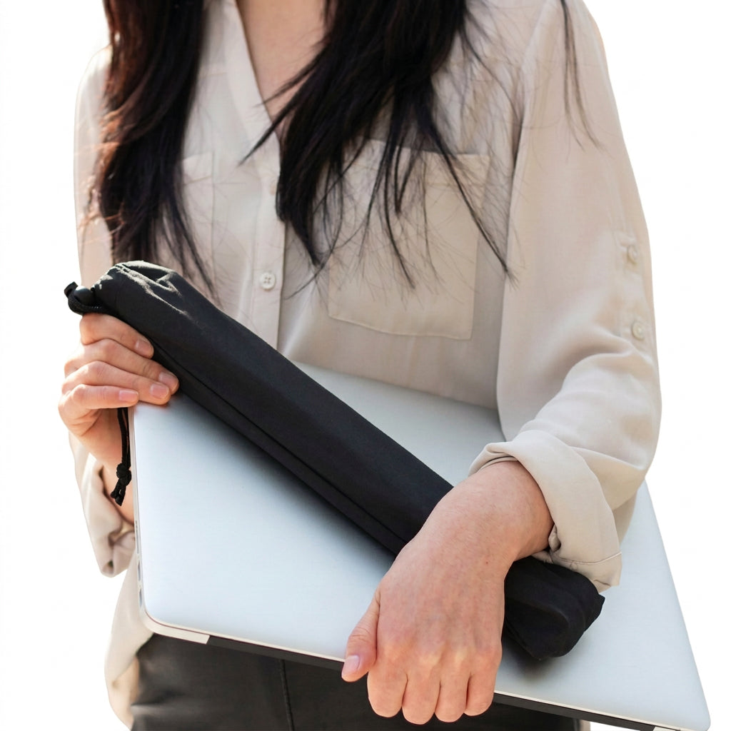 Person holding a closed laptop and a black carrying pouch for a stand