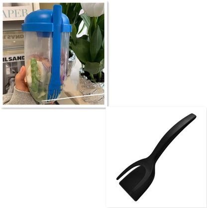 Clear plastic salad cup with blue lid and attached blue fork, filled with sliced vegetables