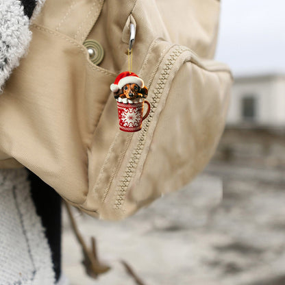Dachshund in Santa hat ornament hanging from tan backpack
