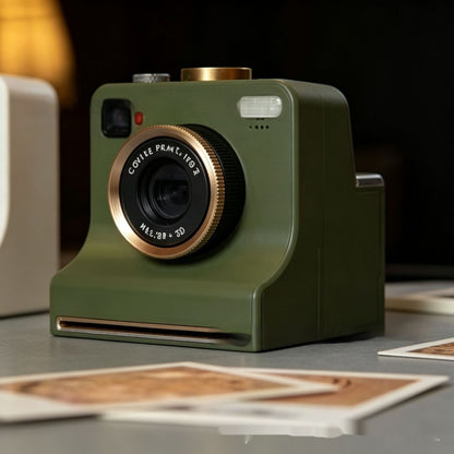 Olive green instant camera with gold lens bezel on a table with printed photo templates.