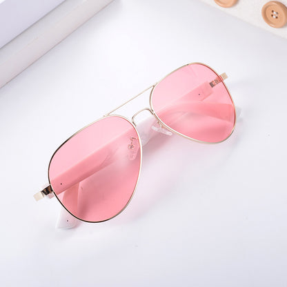 Pink aviator smart wearables with gold frames for real-time translation during travel.