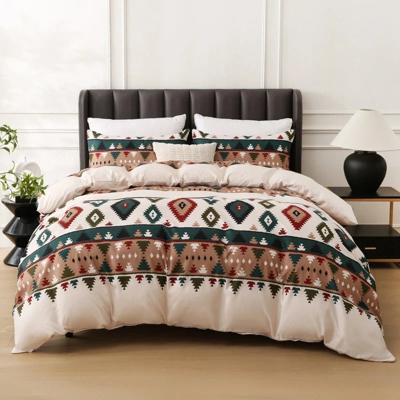 Bedding set featuring geometric Aztec patterns in green, red, brown, and white on a comforter and matching pillow shams.