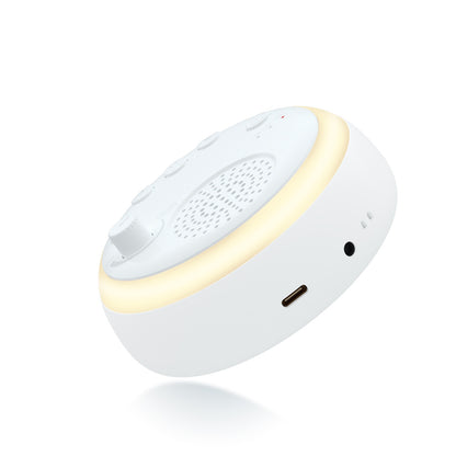 Round white sound machine with glowing light ring, speaker grille, and side charging port