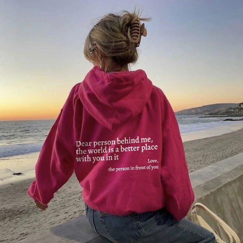 Oversized pink hooded sweatshirt with white letter print for casual daily wear at the beach.