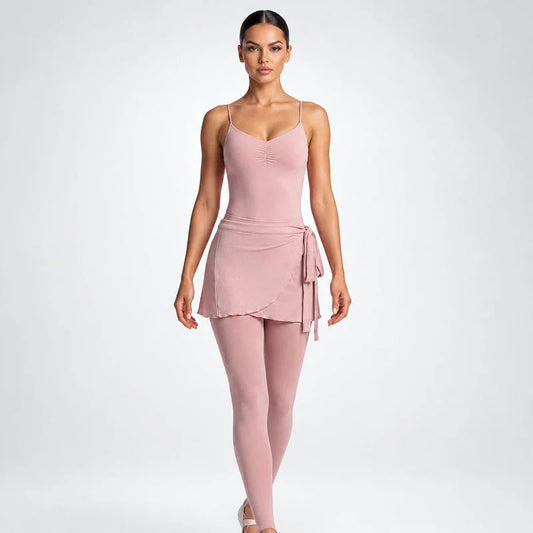 Model wearing a pink workout top, matching leggings, and a wrap skirt tied at the waist, front view.