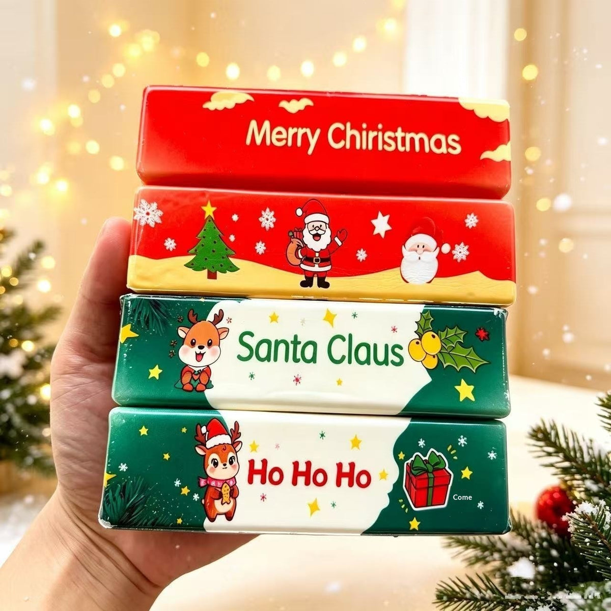 Hand holding a stack of four Christmas butter-stick squishy toys