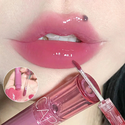 Glossy pink lip gloss applied to lips, with a wand and inset showing swatch on hand.