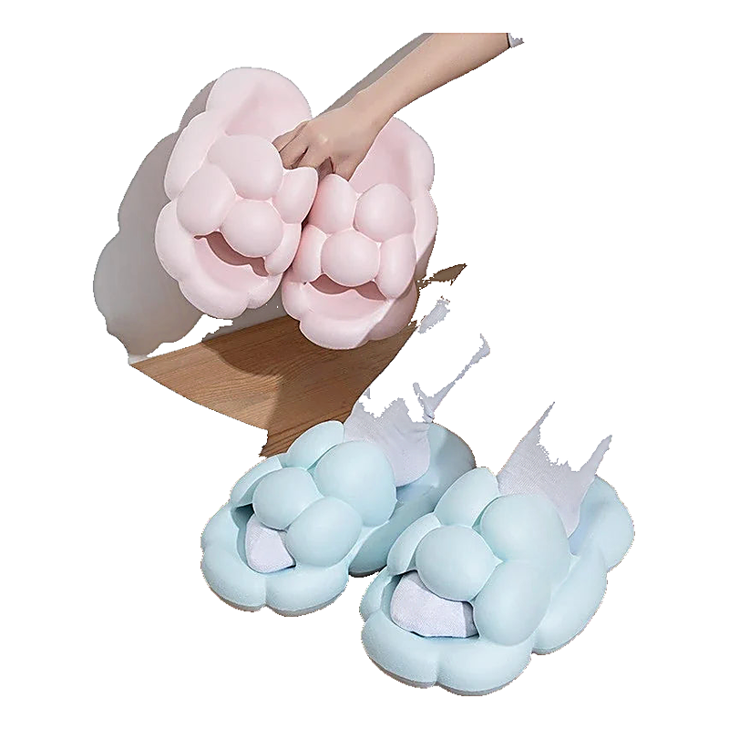 person wearing light blue bubble slide sandals with white socks, holding a pair of pink bubble slide sandals