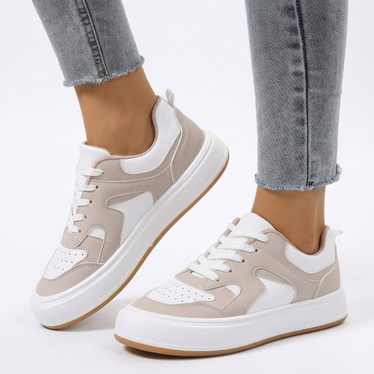 Women's low top platform sneakers in white and beige faux leather paired with jeans