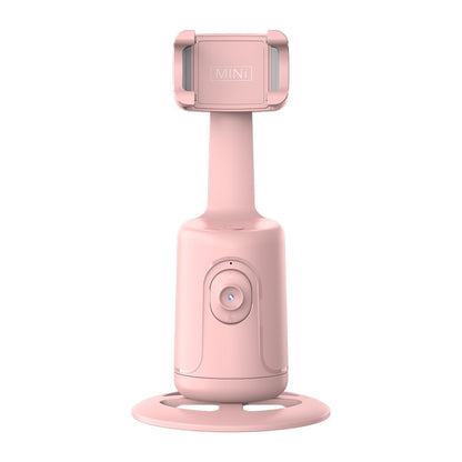 Pink face-tracking phone gimbal with a round base and adjustable clamp.