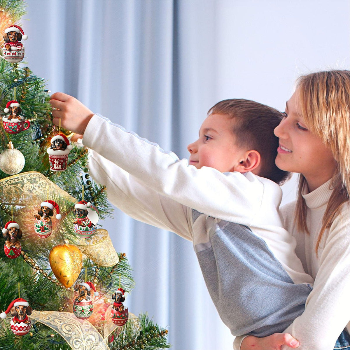 A woman and boy hanging a dachshund Christmas tree ornament.