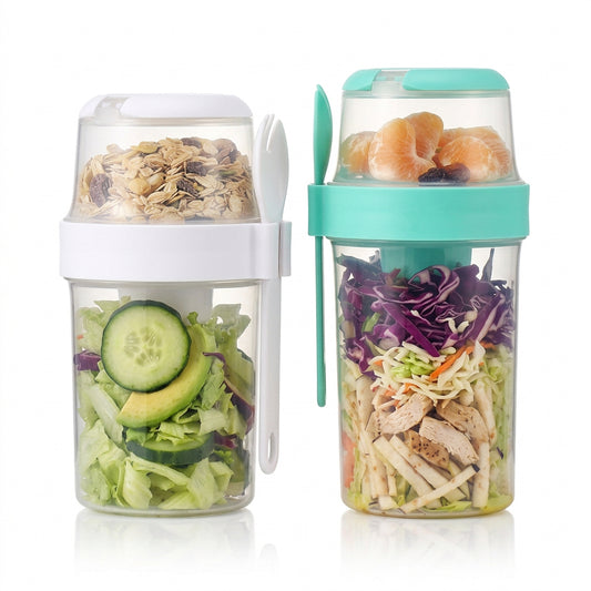 Two portable double-layer salad cups filled with greens, sliced avocado, grains, fruit, and chicken, with attached forks.