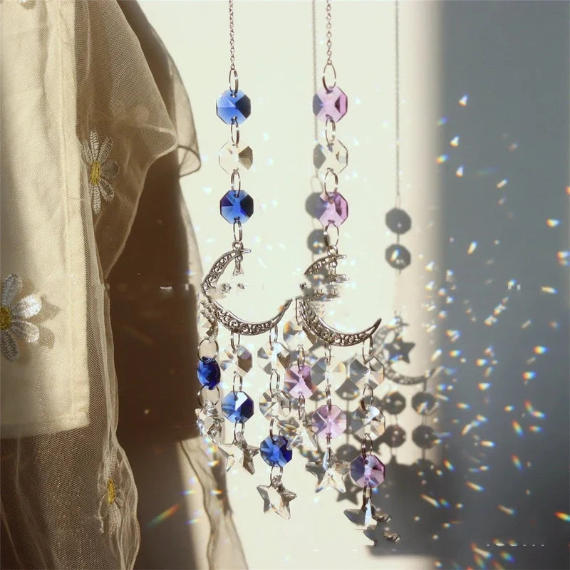 Two crystal suncatchers with blue and purple beads and crescent moon charms casting rainbows.