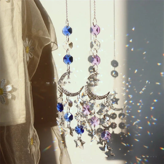 Two crystal suncatchers with blue and purple beads and crescent moon charms casting rainbows.