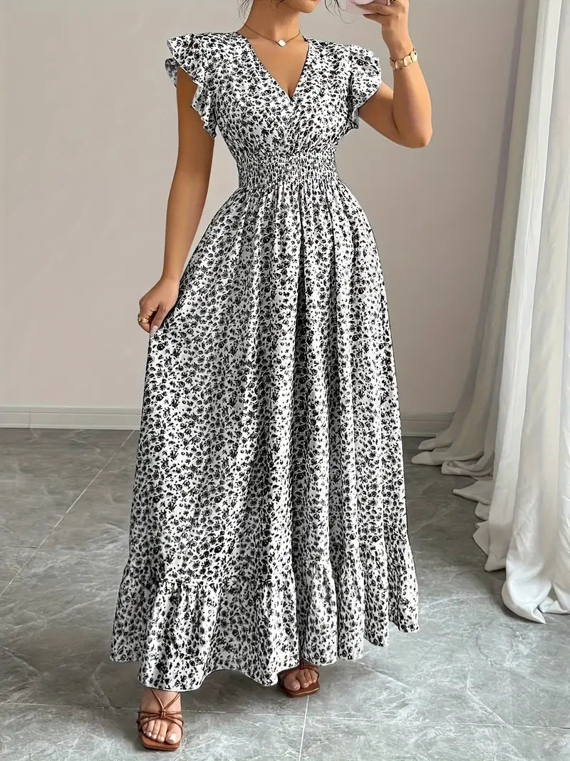 White and black floral polyester flowy dress with flutter sleeves for resortwear.